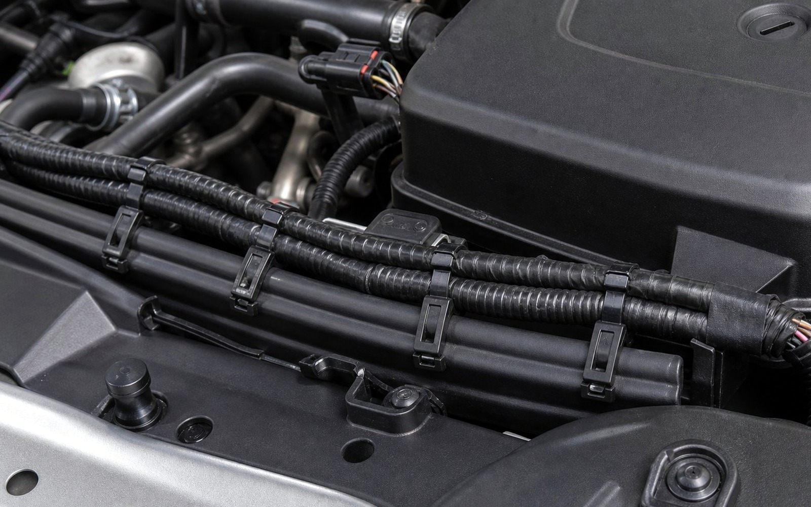 Automotive engine bay wiring harness routed with black cable ties