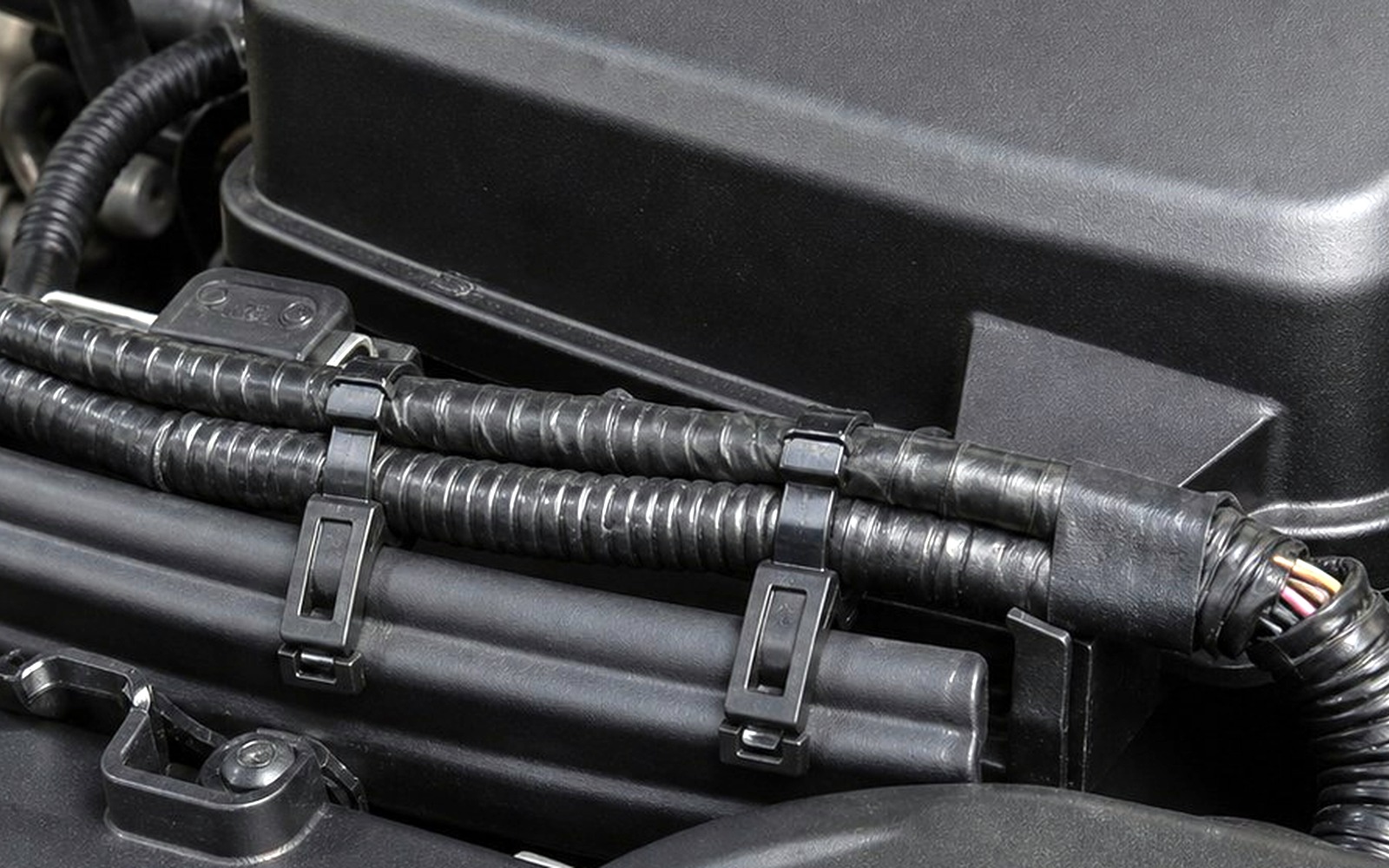 Automotive engine bay harness fixing with service clearance around routed loom