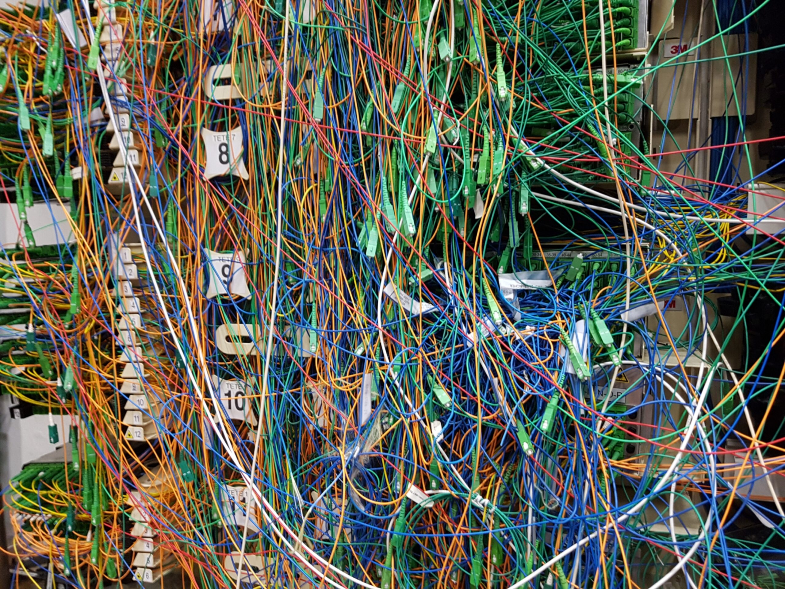 Real damaged and messy optical fibre distribution point showing cable management risk